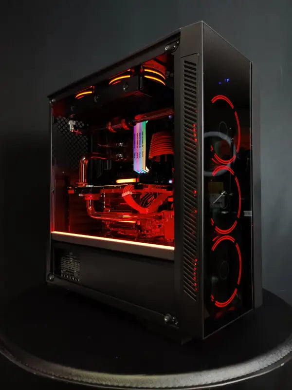 Red-illuminated custom gaming PC featuring Alpha PC liquid cooled design with purple LED lighting
